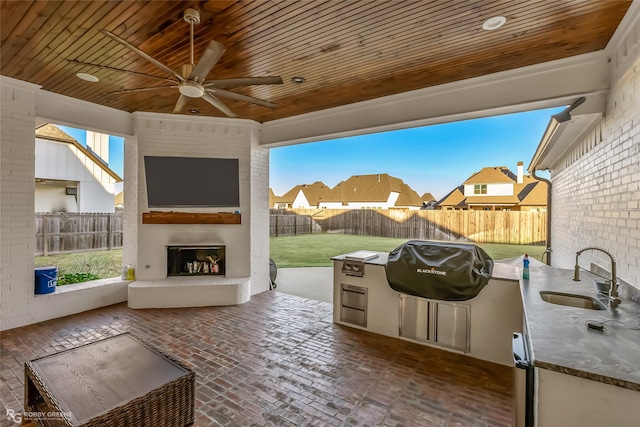 view of patio / terrace with a fireplace, area for grilling, sink, grilling area, and ceiling fan