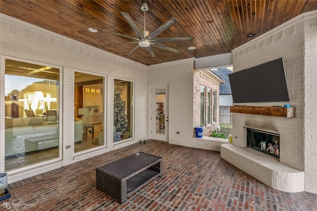 view of patio featuring an outdoor brick fireplace and ceiling fan