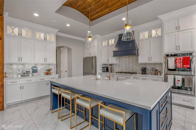 kitchen featuring custom exhaust hood, white cabinetry, and appliances with stainless steel finishes