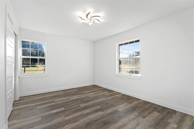 unfurnished room with a healthy amount of sunlight and dark hardwood / wood-style flooring