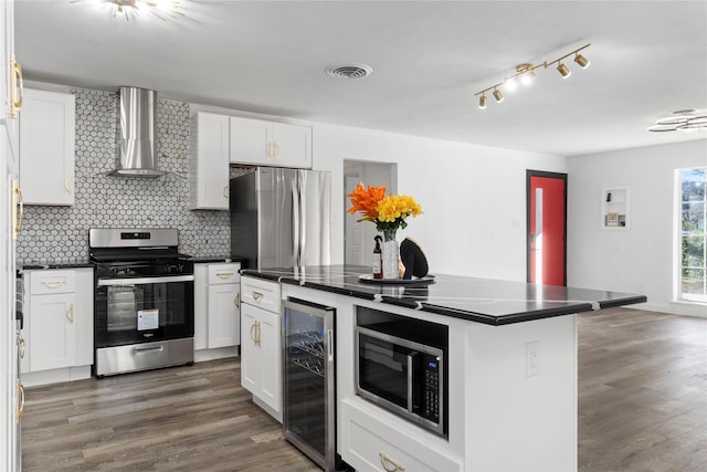 kitchen with wall chimney exhaust hood, a kitchen island, white cabinetry, stainless steel appliances, and beverage cooler