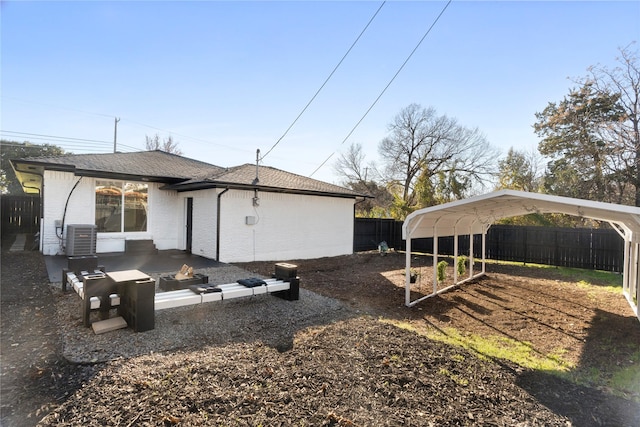 back of property with a carport and central AC unit