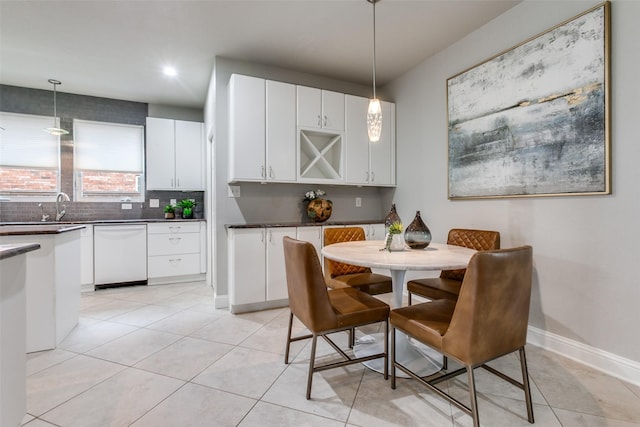 kitchen with backsplash, decorative light fixtures, dishwasher, and white cabinets