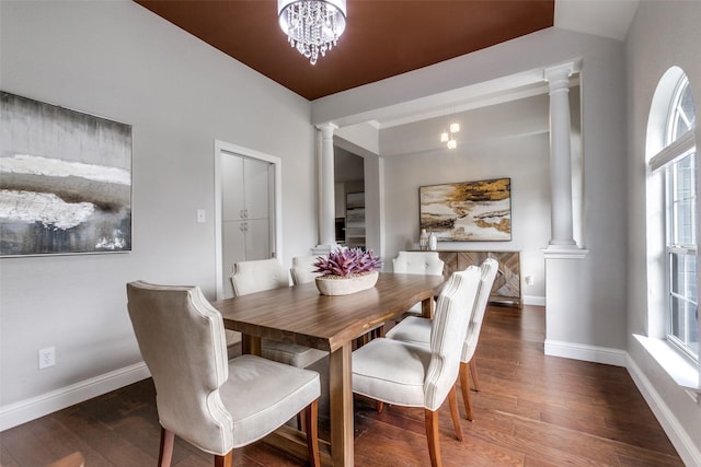 dining room featuring ornate columns, a wealth of natural light, dark hardwood / wood-style flooring, and a notable chandelier