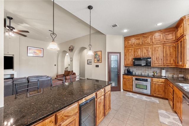 kitchen featuring hanging light fixtures, wine cooler, light tile patterned floors, appliances with stainless steel finishes, and tasteful backsplash