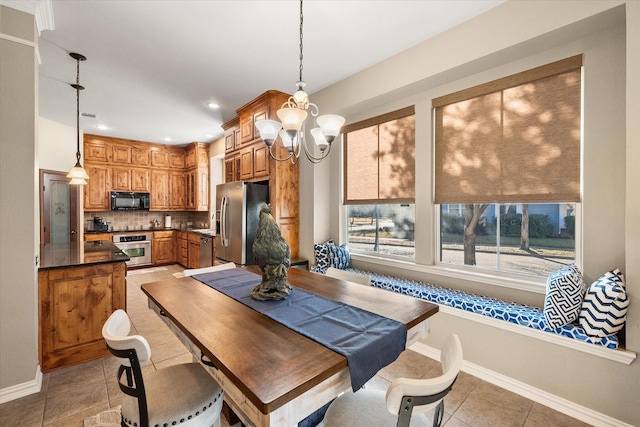 dining area with a chandelier and light tile patterned floors