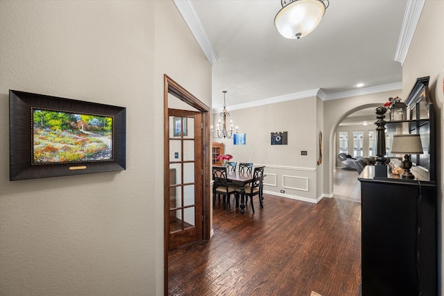 interior space with dark hardwood / wood-style flooring, crown molding, and a chandelier