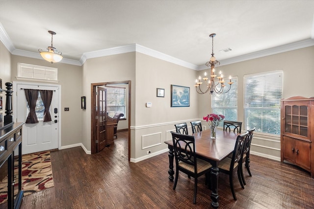 dining space with dark hardwood / wood-style floors, ornamental molding, and a notable chandelier