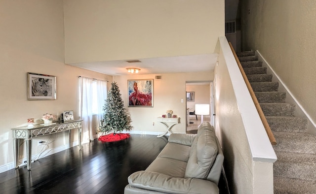 living room featuring wood-type flooring and a towering ceiling