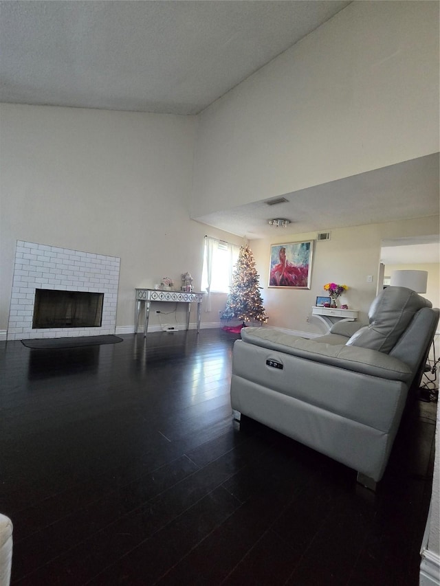 living room with a fireplace, lofted ceiling, and dark hardwood / wood-style floors