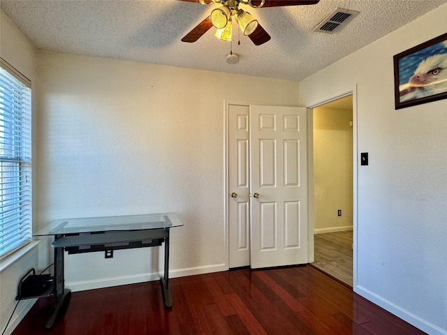 office area with ceiling fan, dark wood-type flooring, and a textured ceiling