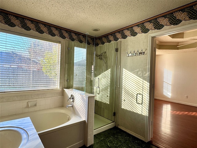 bathroom with plus walk in shower, vanity, and a textured ceiling