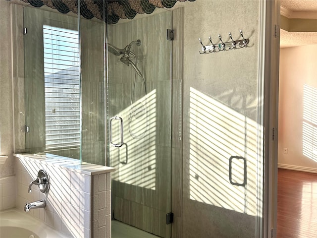 bathroom with plus walk in shower, hardwood / wood-style floors, and ornamental molding