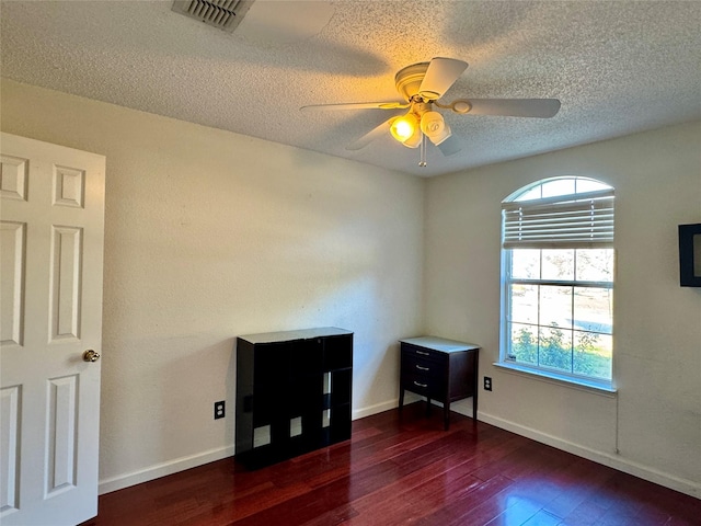 unfurnished room with ceiling fan and dark hardwood / wood-style flooring