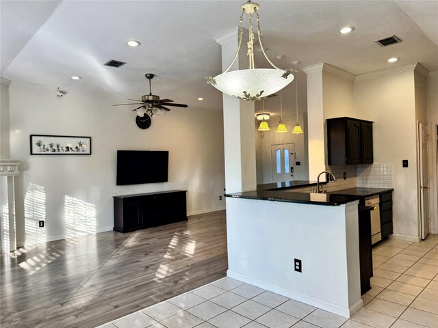 kitchen featuring ceiling fan, hanging light fixtures, tasteful backsplash, kitchen peninsula, and light tile patterned flooring