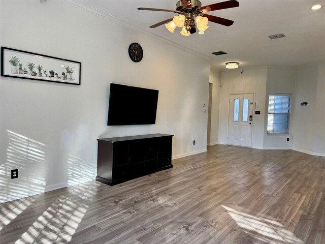 unfurnished living room featuring ceiling fan, hardwood / wood-style floors, and ornamental molding