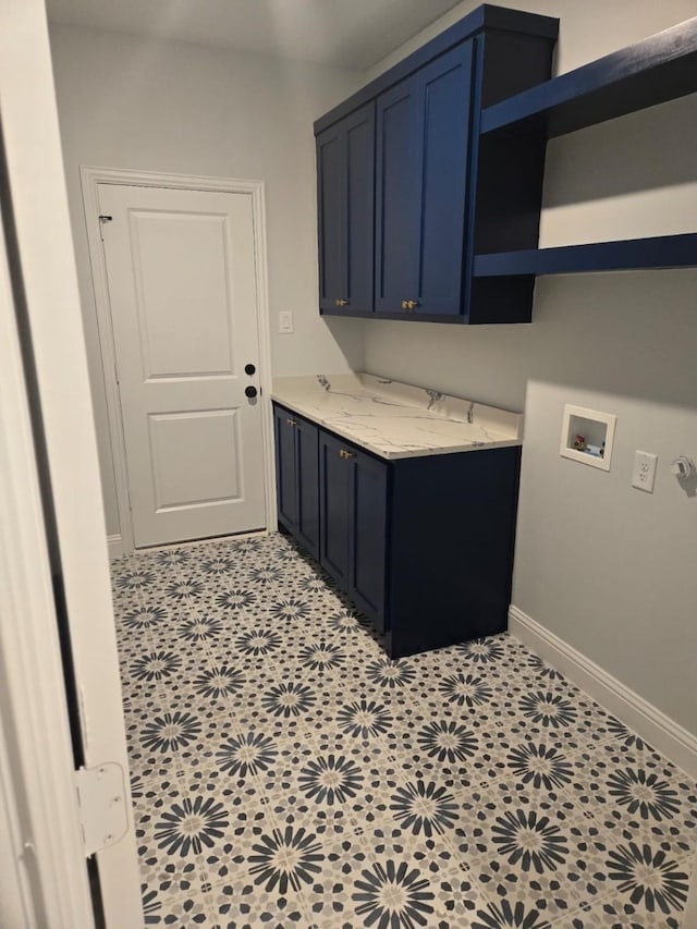 clothes washing area with cabinets, washer hookup, and light tile patterned floors