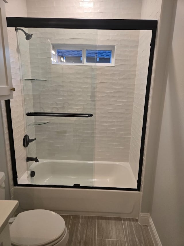 full bathroom featuring shower / bath combination with glass door, vanity, and toilet