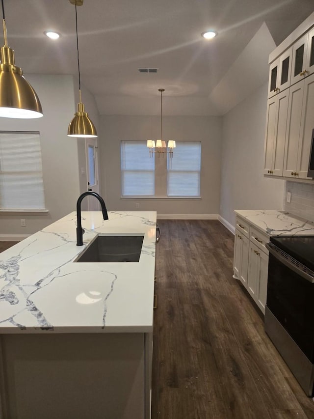 kitchen with pendant lighting, sink, electric range, light stone counters, and white cabinets