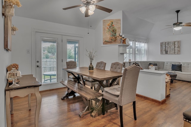 dining space with lofted ceiling, french doors, a ceiling fan, and light wood-style floors