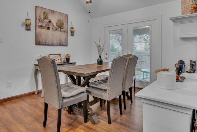 dining space with lofted ceiling, baseboards, a wealth of natural light, and wood finished floors