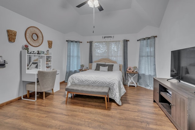 bedroom with vaulted ceiling, ceiling fan, wood finished floors, and baseboards