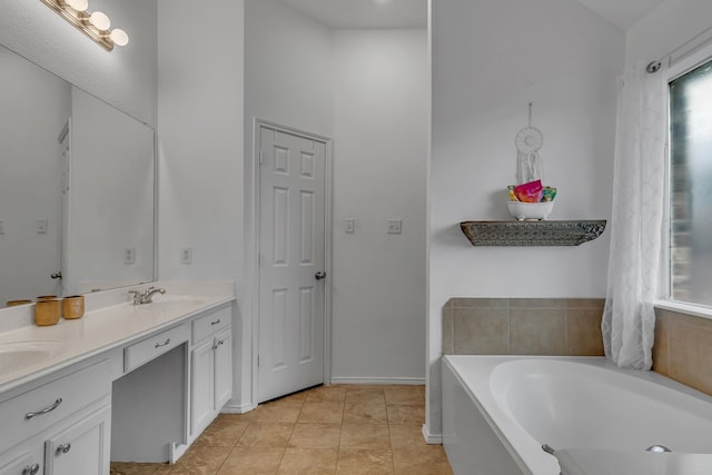 bathroom with tile patterned floors, a garden tub, a sink, and double vanity