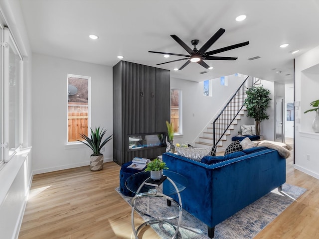 living room with light hardwood / wood-style floors and ceiling fan