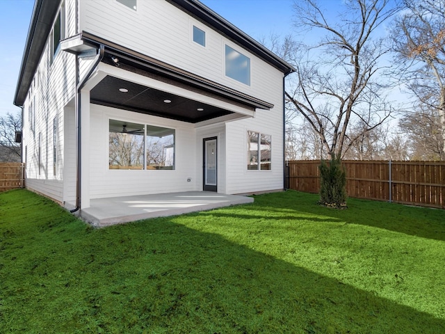 back of house with a yard and a patio