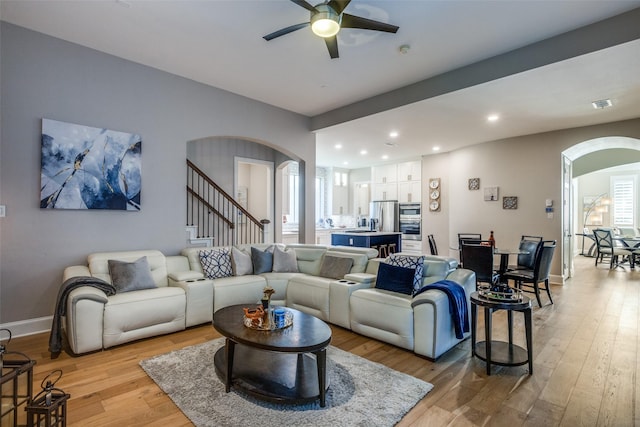 living room with light wood-type flooring and ceiling fan