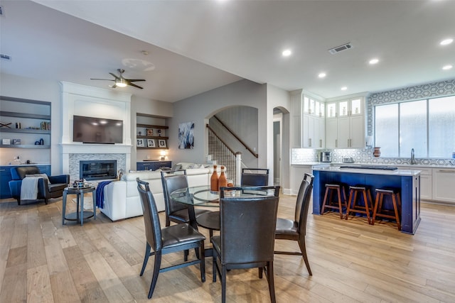 dining space featuring light wood-type flooring, ceiling fan, and sink