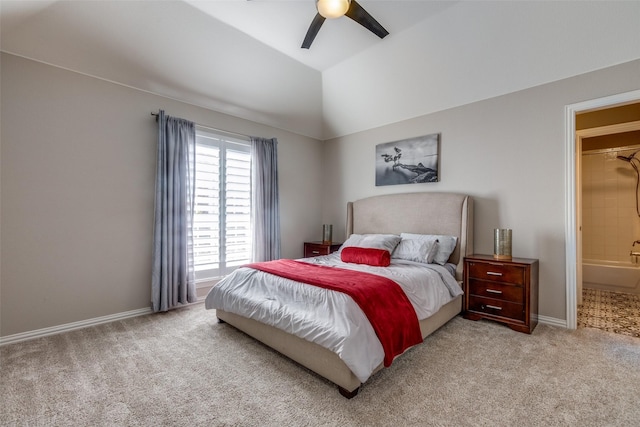 bedroom with ceiling fan, light colored carpet, lofted ceiling, and ensuite bath