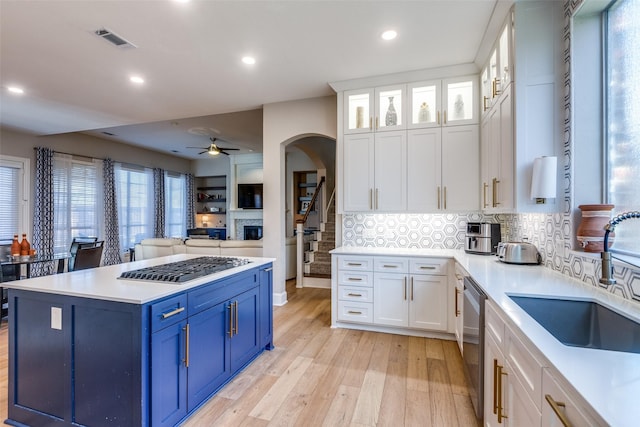 kitchen featuring tasteful backsplash, ceiling fan, sink, blue cabinetry, and white cabinets