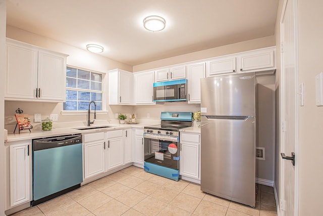 kitchen featuring light tile patterned flooring, appliances with stainless steel finishes, white cabinetry, and sink