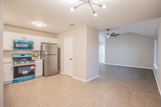 kitchen with lofted ceiling, ceiling fan with notable chandelier, light tile patterned flooring, white cabinetry, and stainless steel appliances