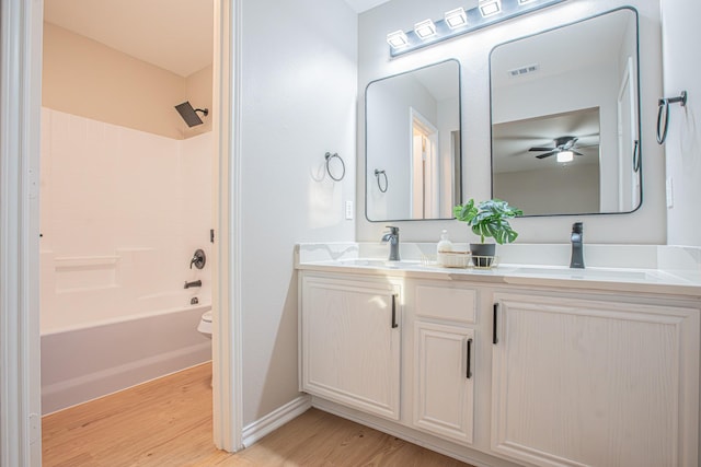 bathroom with wood-type flooring, vanity, and tub / shower combination