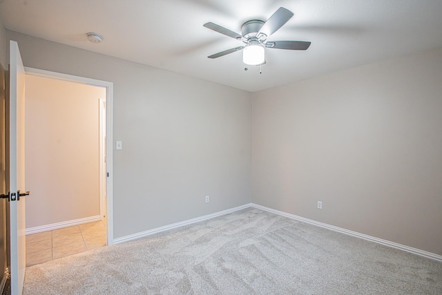 carpeted spare room with ceiling fan