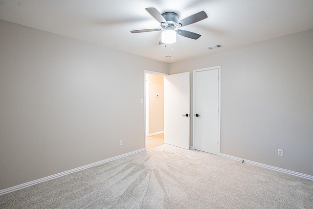 carpeted spare room featuring ceiling fan