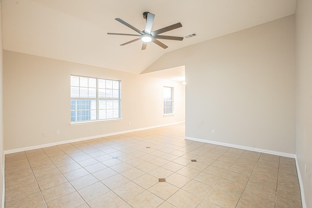 spare room featuring ceiling fan, light tile patterned floors, and vaulted ceiling