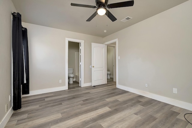 unfurnished bedroom with ensuite bathroom, ceiling fan, and light hardwood / wood-style flooring