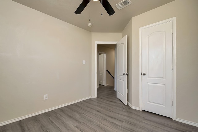 unfurnished bedroom with light wood-style floors, visible vents, baseboards, and a ceiling fan