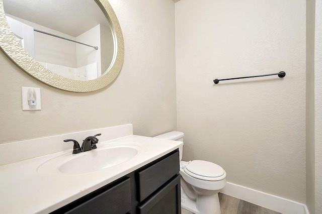 bathroom with vanity, toilet, and wood-type flooring