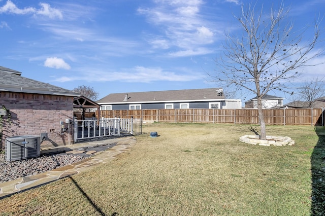 view of yard with a fenced backyard and central air condition unit