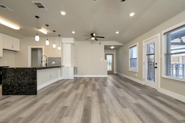 kitchen with dark countertops, visible vents, ceiling fan, and vaulted ceiling