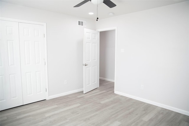 unfurnished bedroom with a closet, light hardwood / wood-style flooring, and ceiling fan