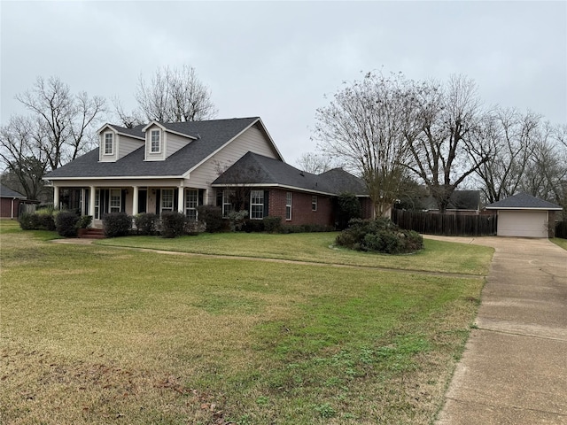 view of front of home with covered porch, a garage, a front lawn, and an outdoor structure