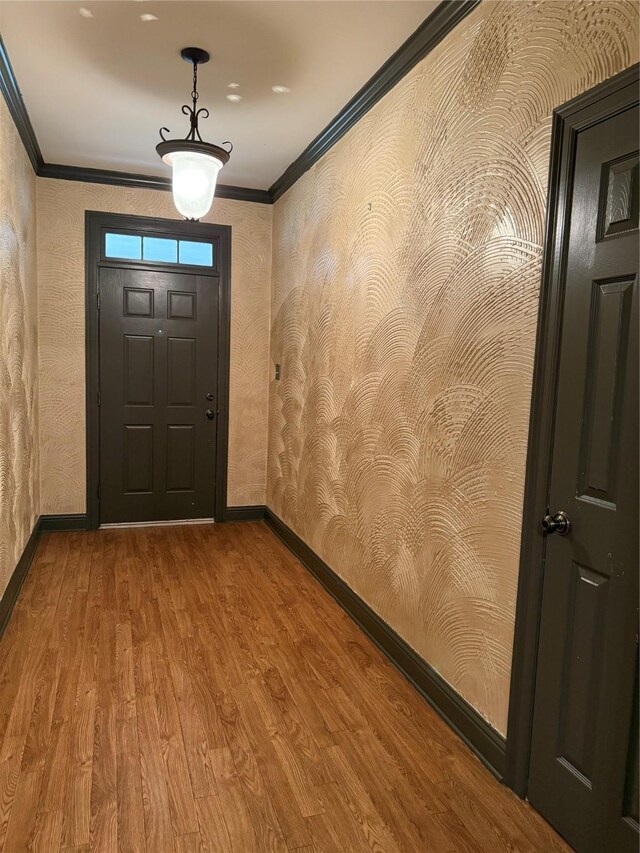 entryway featuring hardwood / wood-style flooring and ornamental molding