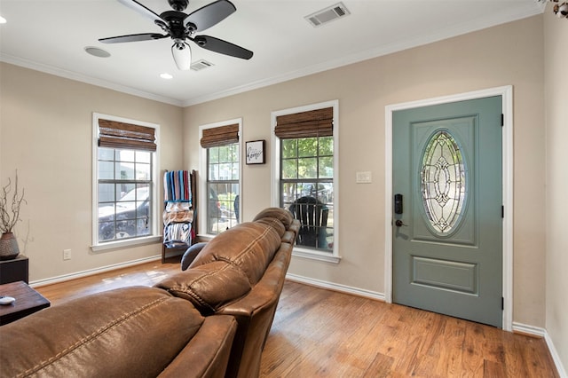 foyer with ceiling fan, crown molding, and light hardwood / wood-style flooring