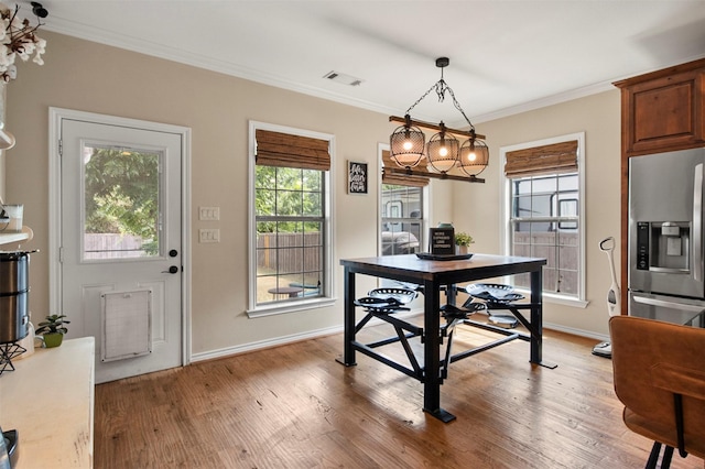 dining area featuring hardwood / wood-style flooring and crown molding