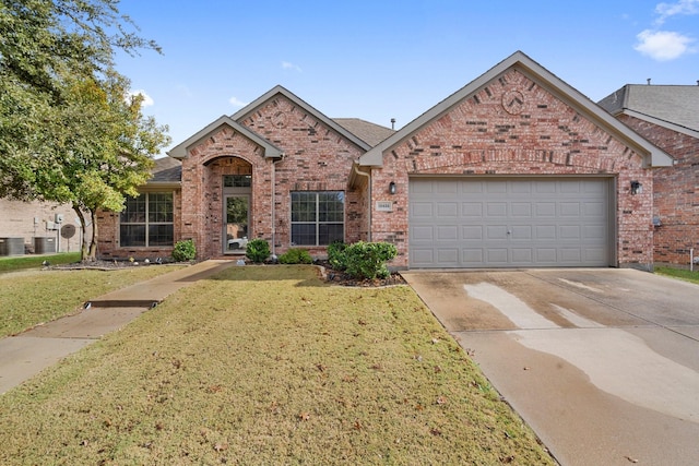 view of front of property featuring central air condition unit, a front lawn, and a garage